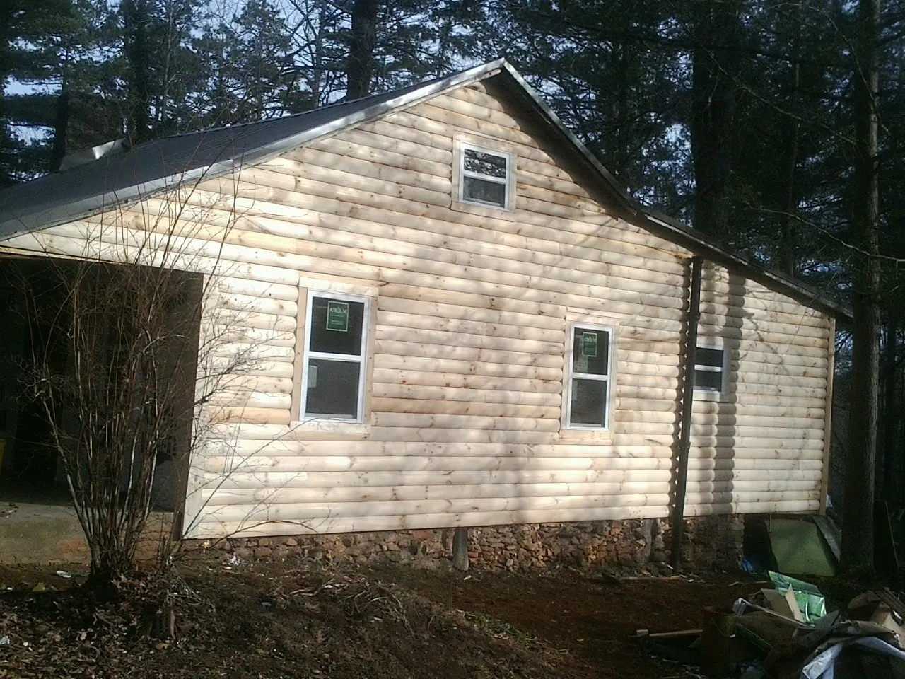 New log siding and dark metal roofing on a gable end in Mount Horeb