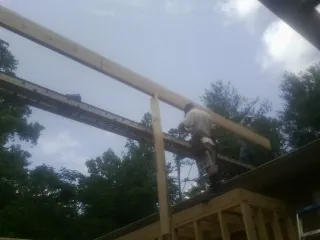 Carpenter setting a ridge beam over a new addition frame — Ice Dam Removal by Roofing Brothers in Mount Horeb
